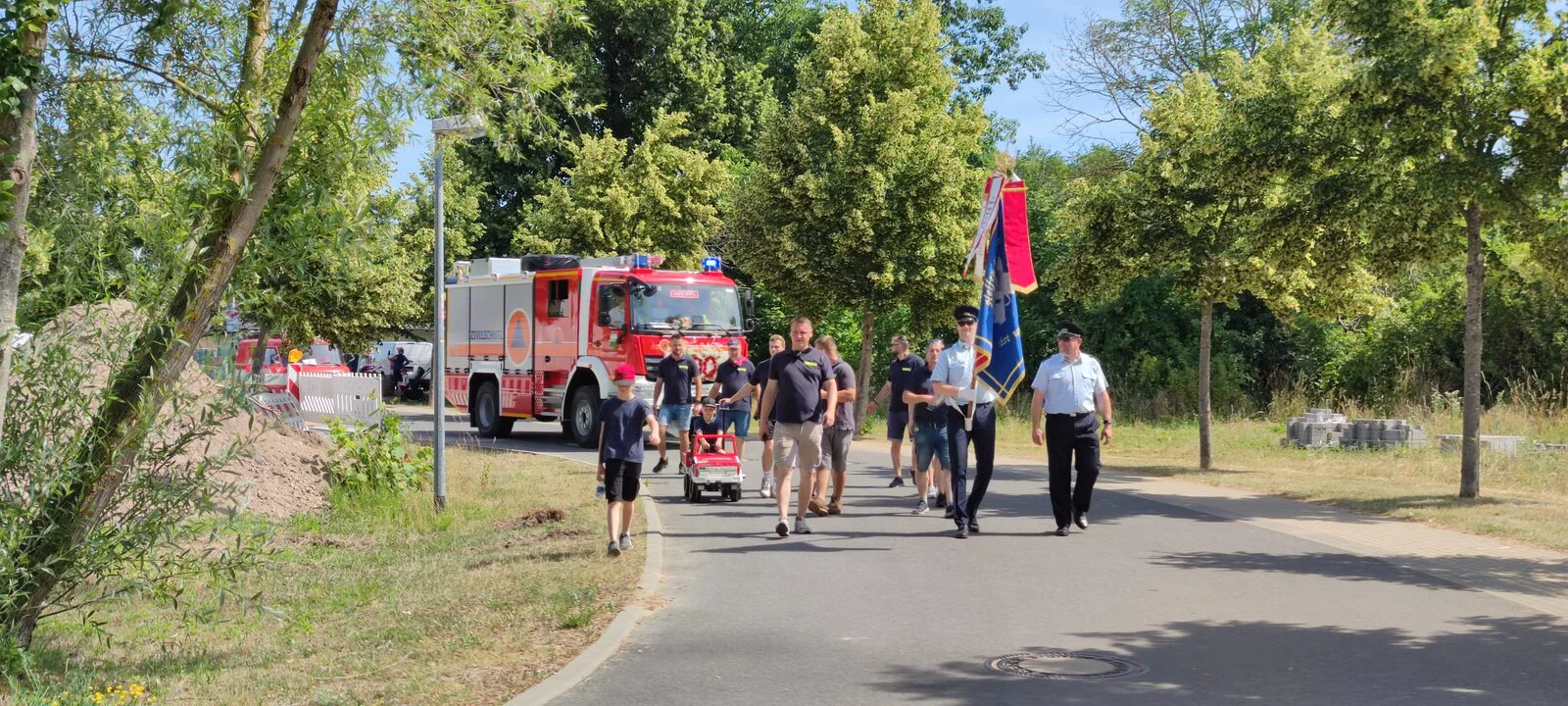 Festumzug zum 100-jährigen Jubiläum der Freiwilligen Feuerwehr Klosterdorf mit Vereinsfahne und Löschfahrzeug