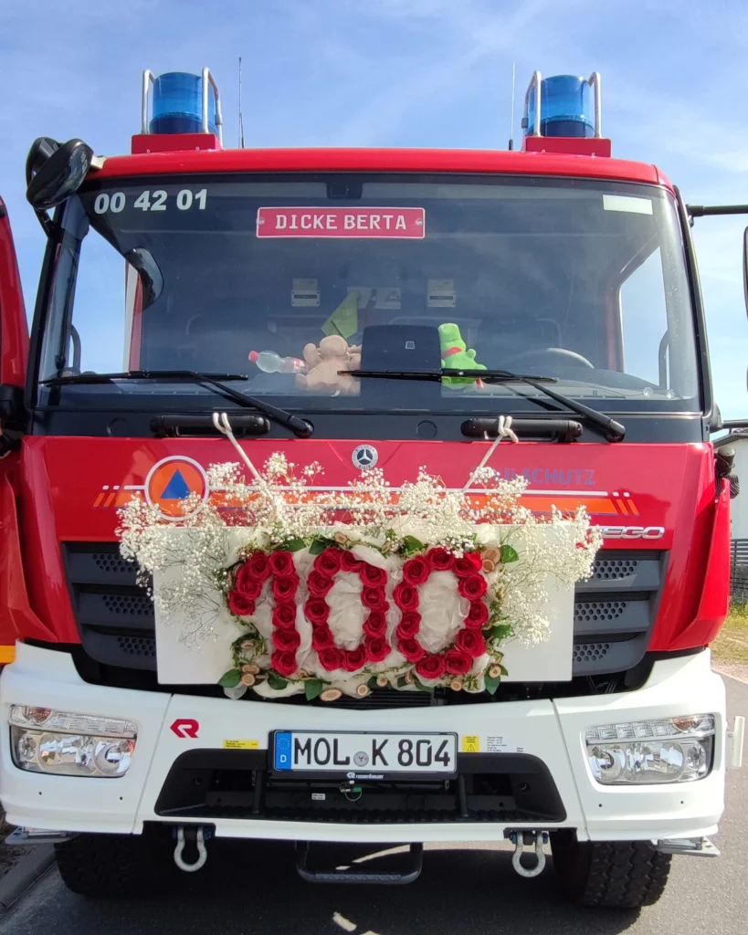„Dicke Berta“ von vorn, mit dem Blumenschmuck zum Jubiläum am Kühlergrill